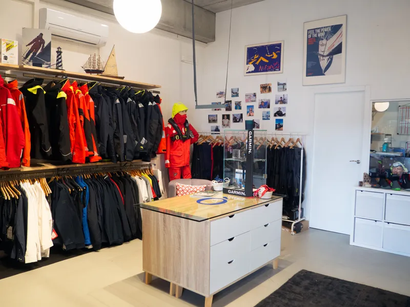 Interior del showroom, amb rails de roba tècnica de mar i un maniquí amb equip d'aigües.