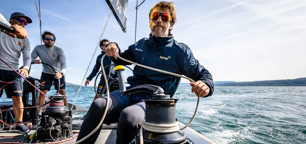 Tripulació treballant a coberta durant una regata, tota amb la mateixa jaqueta tècnica marcada.